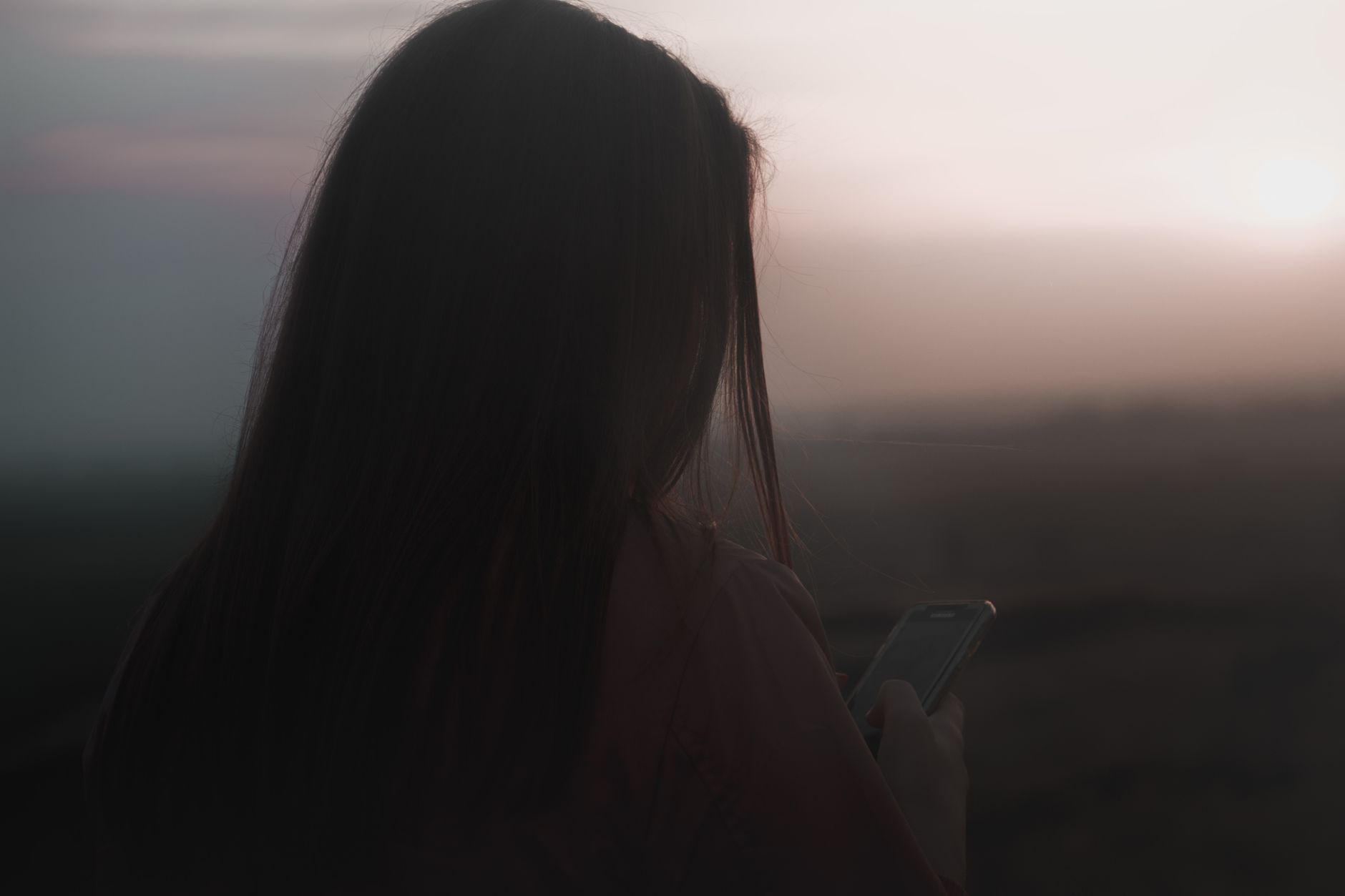 A hand holding a smartphone displaying encrypted messages