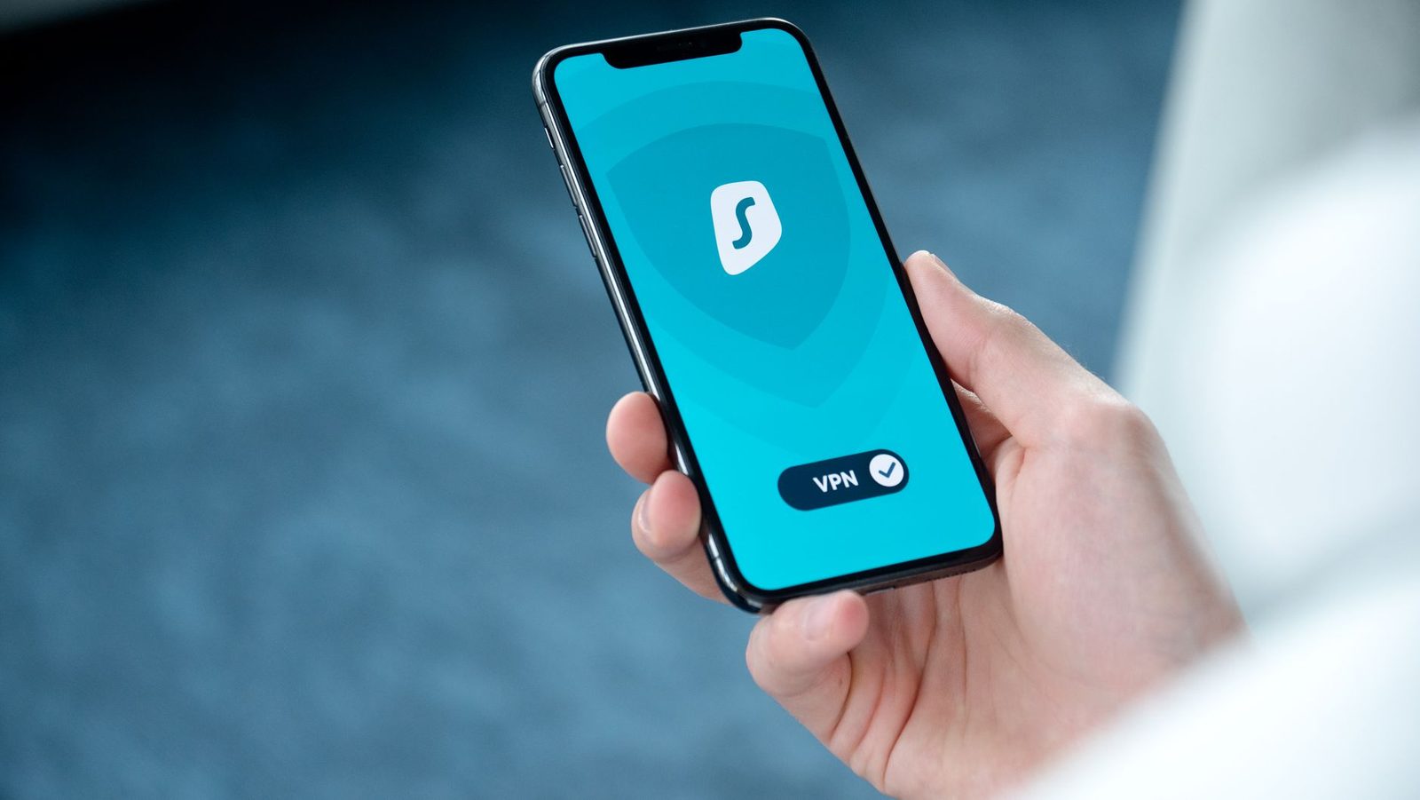 Hand hält ein Smartphone, auf dessen Bildschirm eine aktivierte VPN-App zu sehen ist