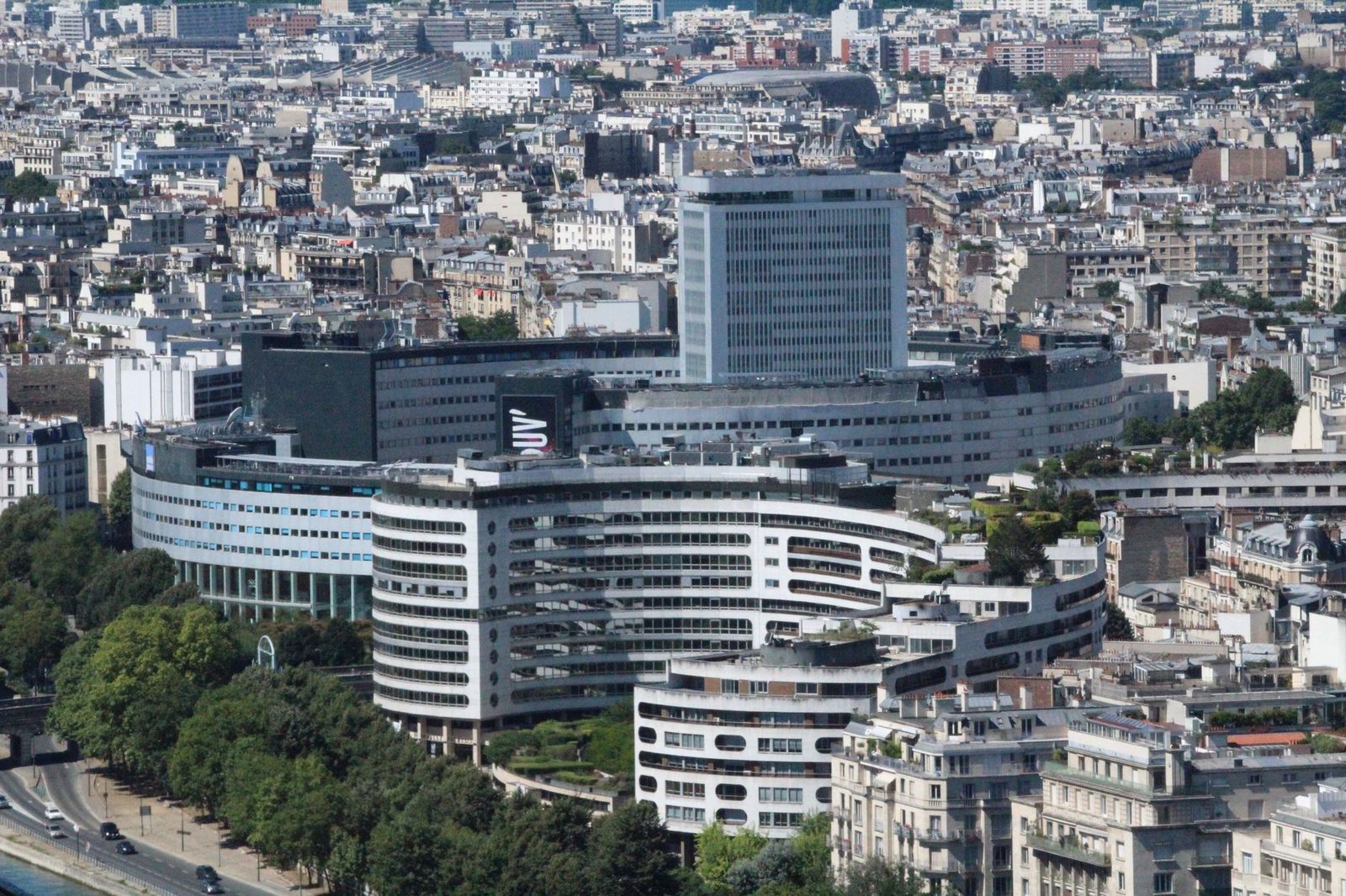 Vue aérienne d'immeubles de bureaux et d'habitation à Paris, avec avenue bordée d'arbres au premier plan