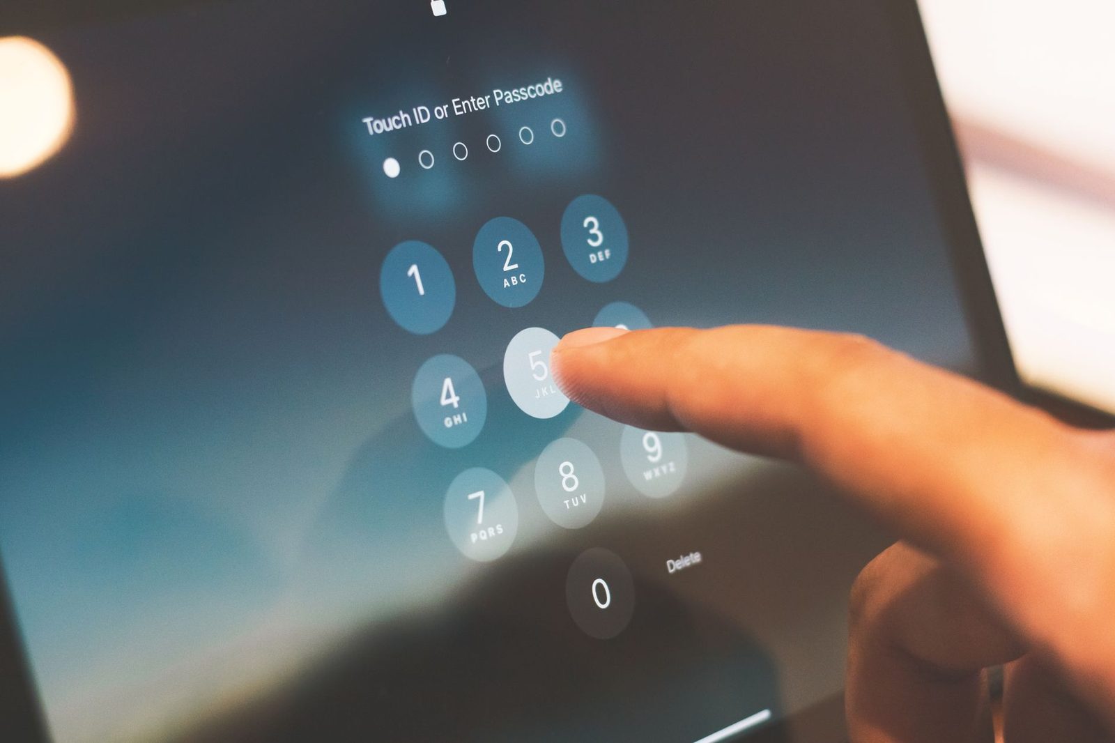 Dito che digita un codice di sblocco sullo schermo touch di uno smartphone