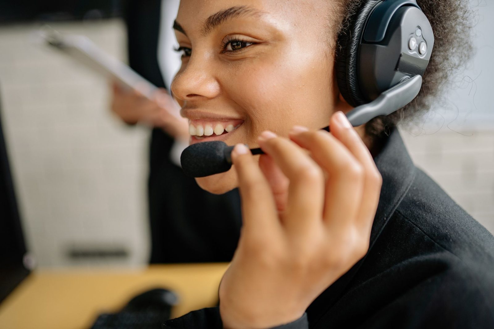 Smiling young woman wearing a call-operator headset in a call centre